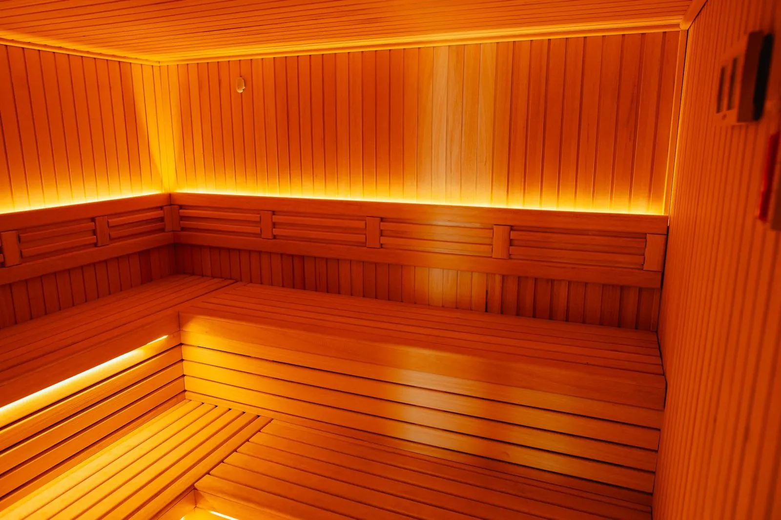Sauna sa drvenim klupama i toplim svetlom