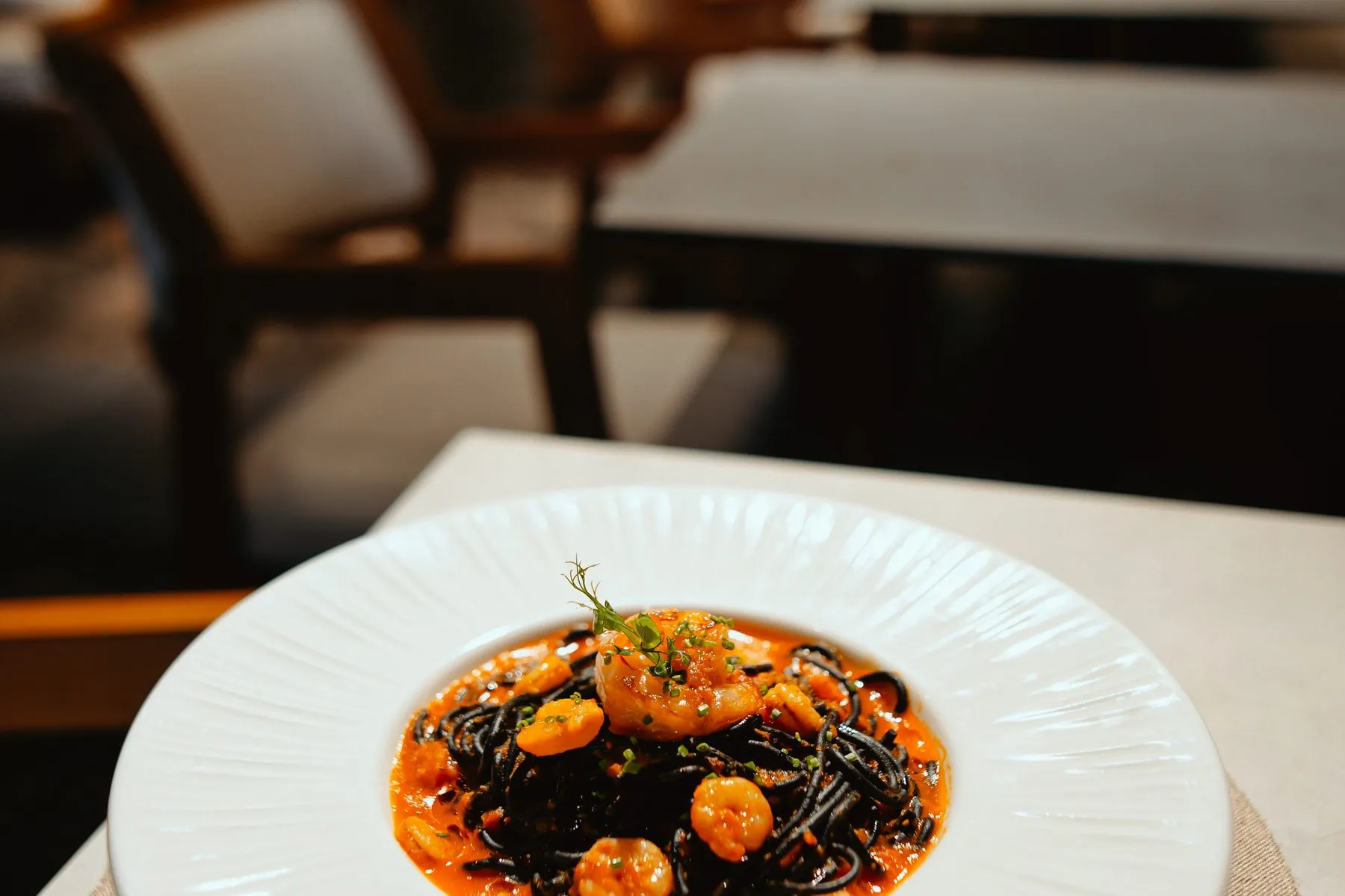 Black pasta with prawns, a table in the dining room