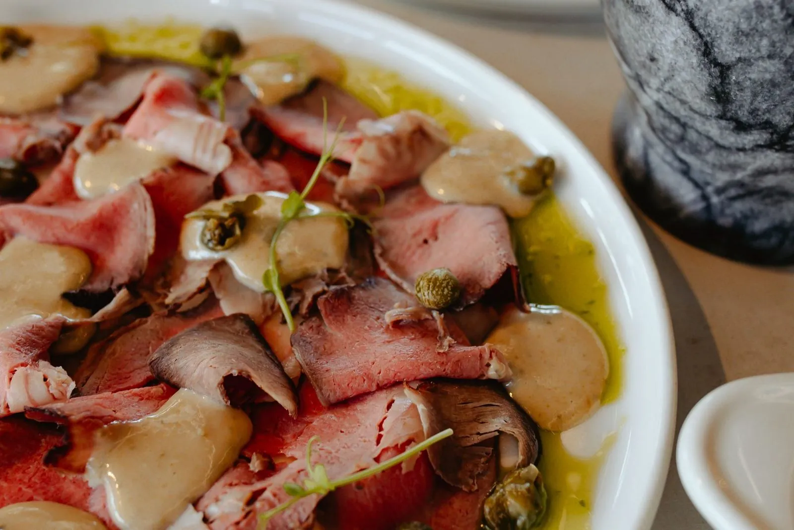 Thinly sliced meat with capers and olive oil